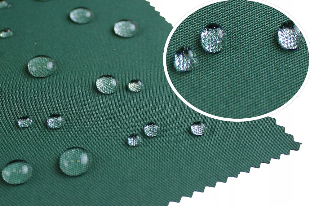 Капельки воды на зеленой ткани